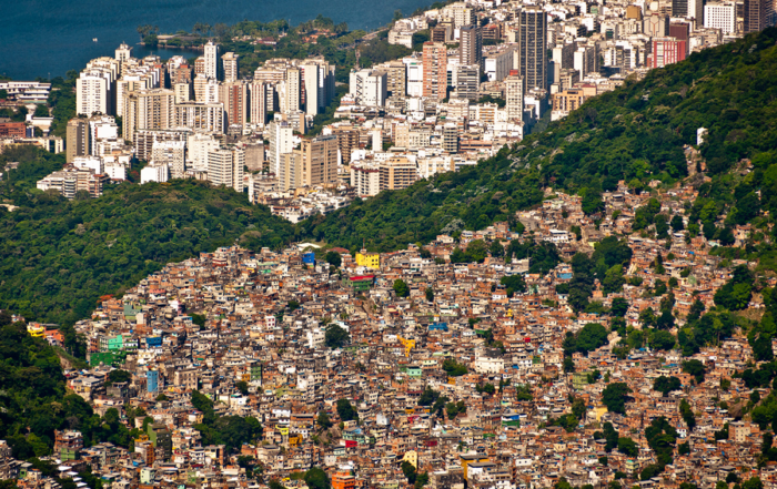 comunidade vista de cima e uma divisão feita e árvores e que mostra prédios de alto padrão deixando claro a desigualdade social