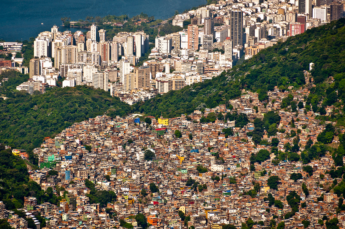 comunidade vista de cima e uma divisão feita e árvores e que mostra prédios de alto padrão deixando claro a desigualdade social